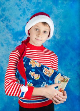 Mavi kutu tutan Santa şapkalı çocuk