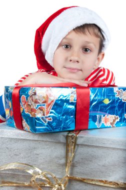 İzole kutuları üzerinde döşeme kırmızı Santa şapkalı çocuk