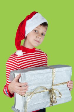 Gümüş kutu yeşil zemin üzerine tutarak Santa şapkalı çocuk