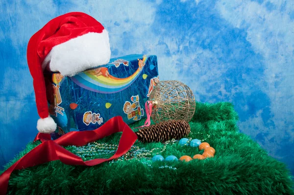 Různé vánoční dárky se Santa hat na modrém pozadí — Stock fotografie