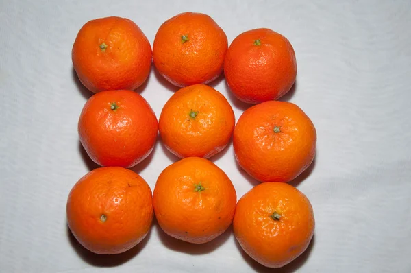 Neun reife Mandarinen auf weißem Tisch — Stockfoto