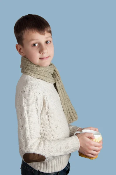 Симпатичный мальчик с белой чашкой на синем фоне — стоковое фото
