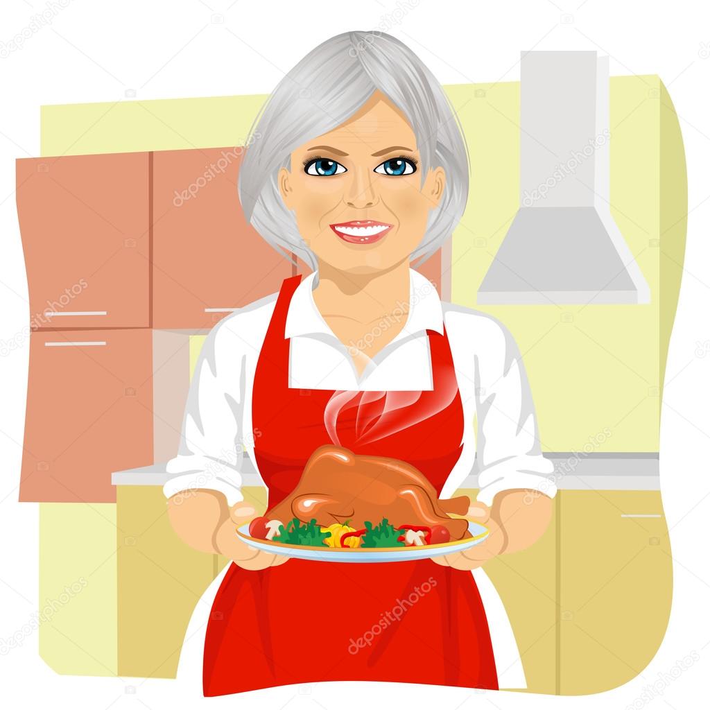 Sweet grandmother in red apron cooking traditional thanksgiving turkey