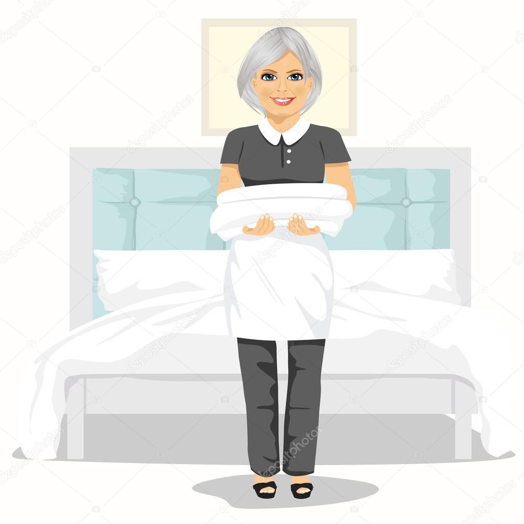 Mature maid woman with towels and bed sheets. House cleaning service concept