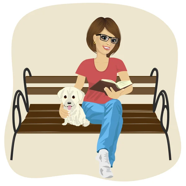 Giovane donna felice godendo di tempo libero fuori lettura libro seduto su una panchina abbracciando cucciolo labrador — Vettoriale Stock