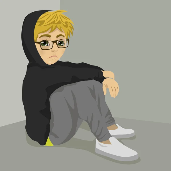 Adolescente nerd menino desesperado sentado no chão sobre fundo cinza com roupas escuras — Vetor de Stock