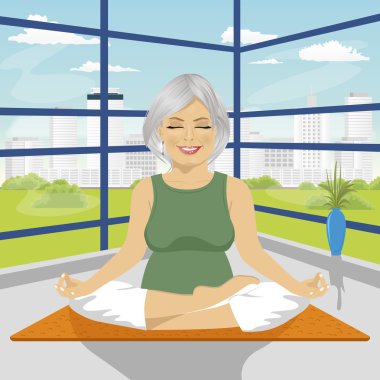 lotus mindere oturmuş pozisyonda yoga egzersizleri yapıyor kadın kıdemli