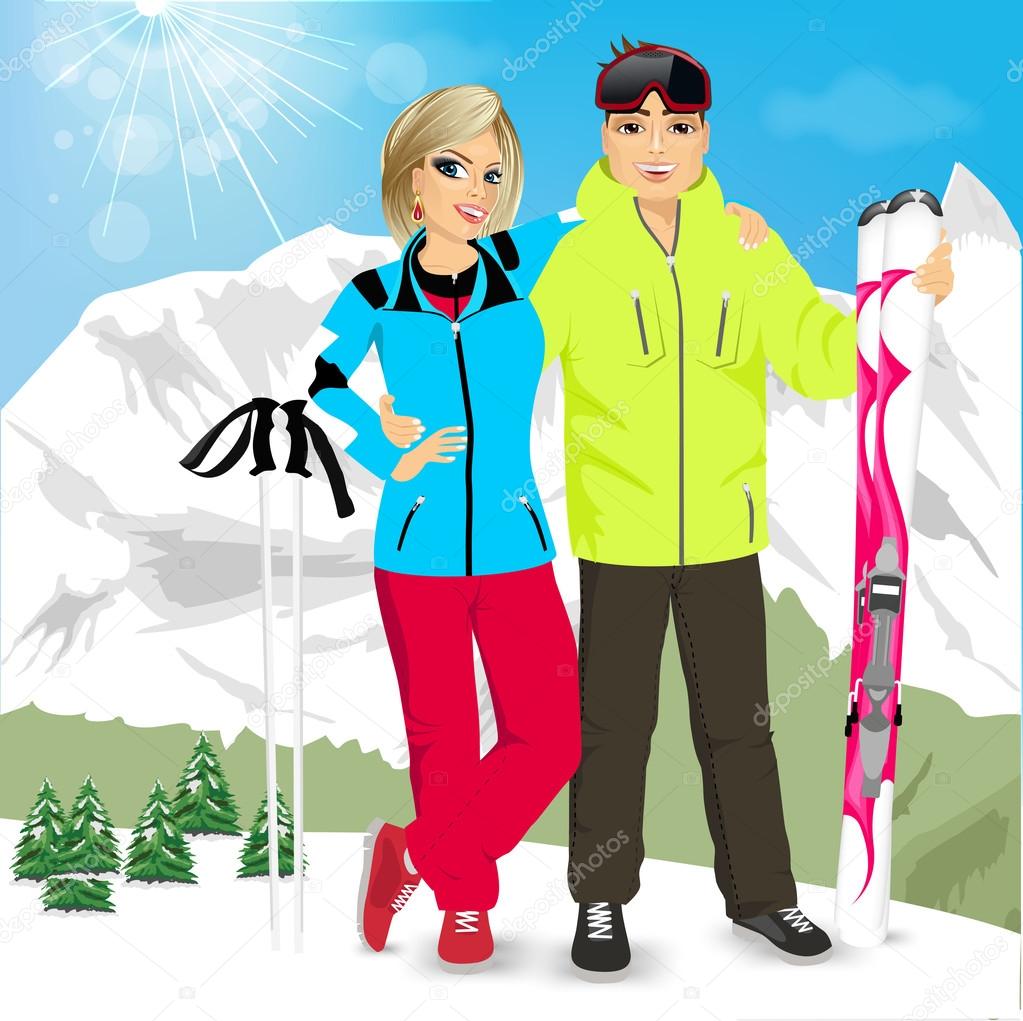 happy couple skiers standing on edge of mountain peaks
