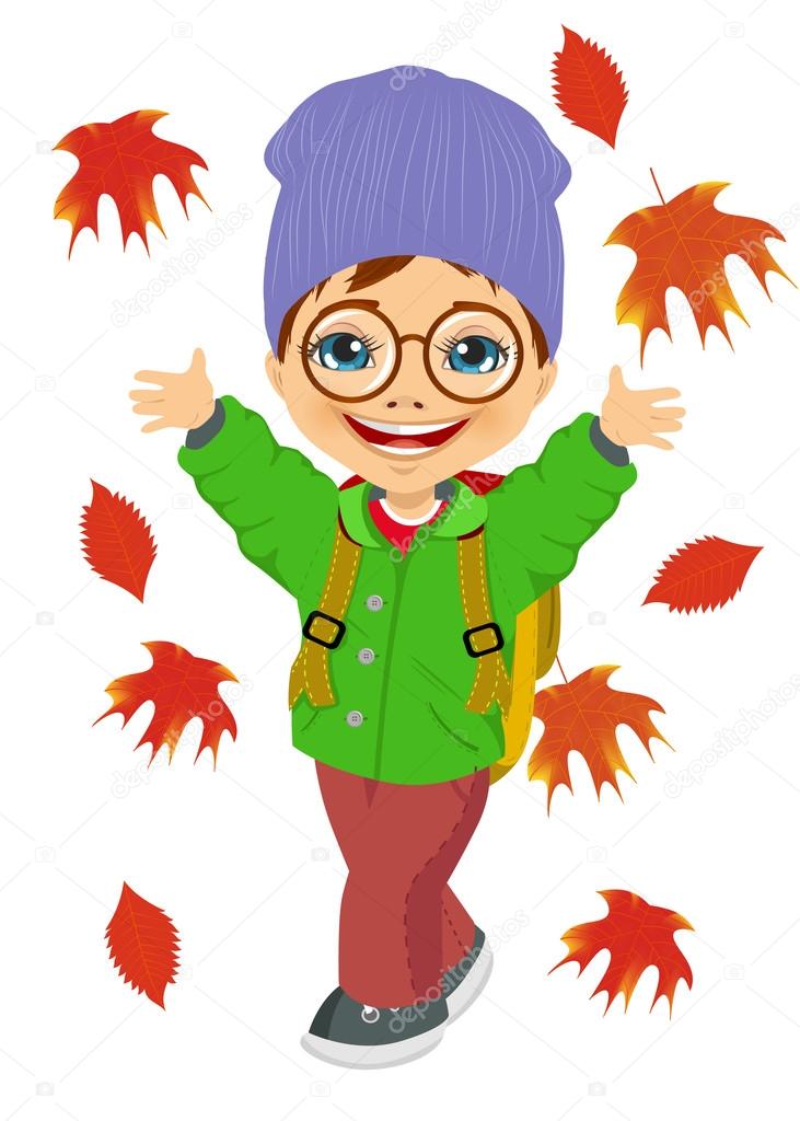 little boy wearing knitted hat playing with autumn leaves