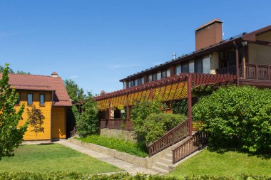 Ağaçları ve çalıları olan güzel bir bina.