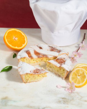 Napoliten Paskalya Pasta krema şeker serpilir ve badem çiçeği ve taze meyve ile dekore edilmiş.