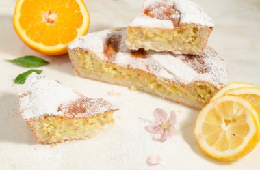 Napoliten Paskalya Pasta krema şeker serpilir ve badem çiçeği ve taze meyve ile dekore edilmiş.