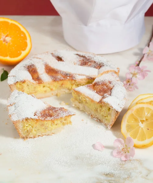 Napoliten Paskalya Pasta krema şeker serpilir ve badem çiçeği ve taze meyve ile dekore edilmiş.