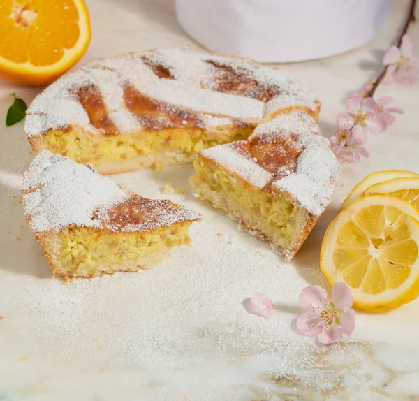 Napolitanska påsk paj bevattnas med florsocker och inredda med almond blossom och färsk frukt. — Stockfoto