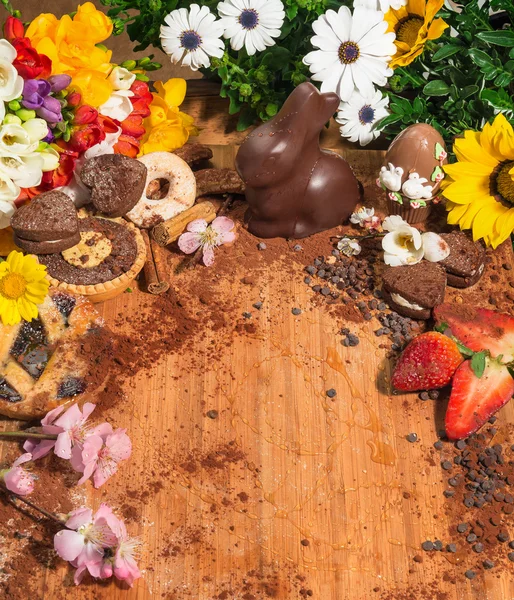 Easter composition with spring flowers,chocolate egg and Easter rabbit,and a wide choice of chocolate cookies,shortbreads and fresh fruits. — Stock Photo, Image