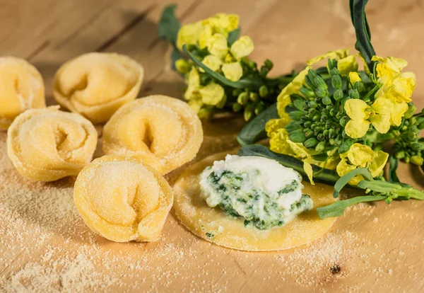 Tortellini italiano casero, abierto y cerrado, relleno de queso ricotta y brócoli fresco . — Foto de Stock