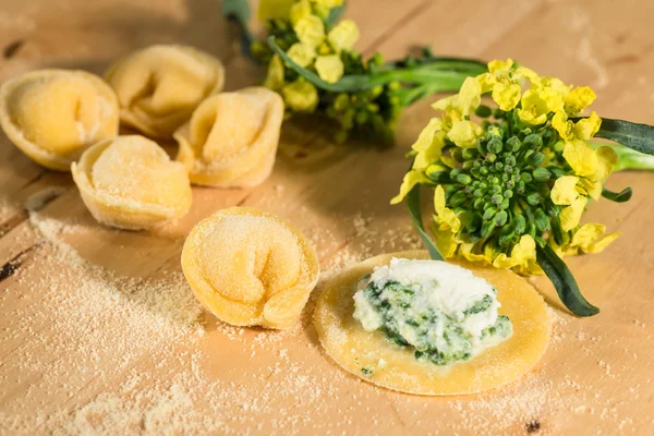 Tortellini italiano casero, abierto y cerrado, relleno de queso ricotta y brócoli fresco . — Foto de Stock