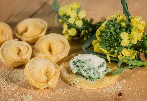 Tortellini italiano casero, abierto y cerrado, relleno de queso ricotta y brócoli fresco . — Foto de Stock