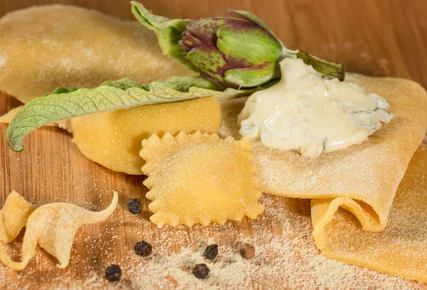 Gorgonzola peyniri, taze enginar ve birkaç karabiber taneleri ile İtalyan ev yapımı mantı.