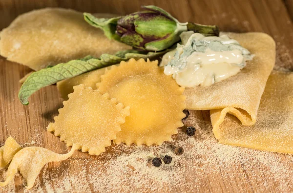 Olasz házi ravioli, gorgonzola sajttal, friss articsóka és néhány szem fekete bors. — Stock Fotó