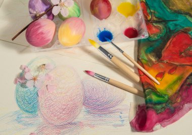 Paskalya yumurtaları ressam fırçalar, renkli kumaş, suluboya ve renkli bir resim tarihinde düzenlenmiş badem çiçeği ile el boyaması.