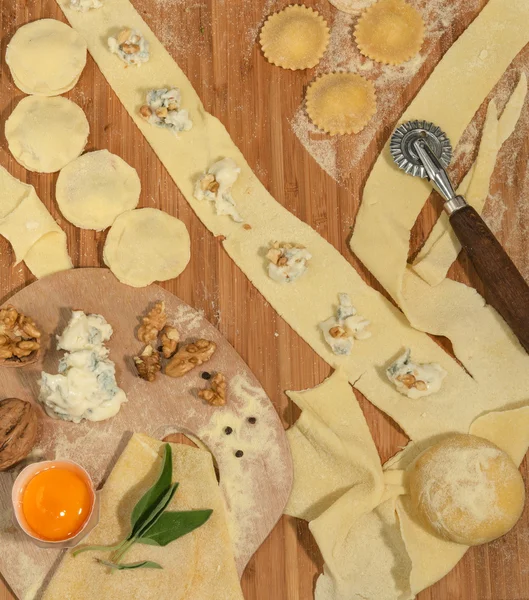Gorgonzola, ceviz, un, yumurta, çiğ hamur ve aromatik otlar ile ev yapımı İtalyan Mantısı rustik ahşap bir masa yerleştirilen.