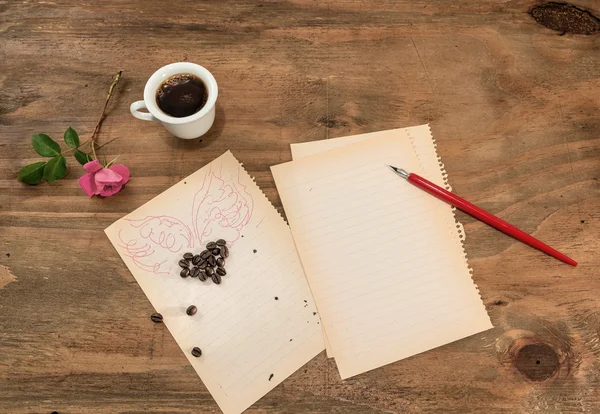 Una taza de café negro con un corazón alado . — Foto de Stock