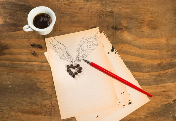 Cup of black coffee with  a winged heart. — Stock Photo, Image