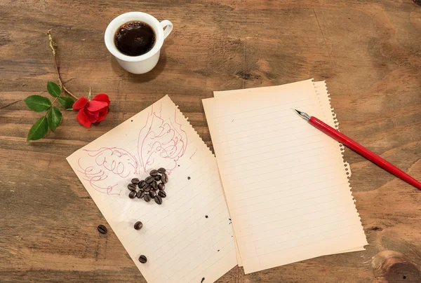 Una taza de café negro con un corazón alado . —  Fotos de Stock