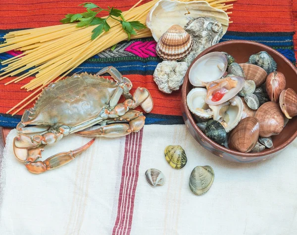 Cangrejo, mariscos con espaguetis y conchas sobre tela étnica . —  Fotos de Stock