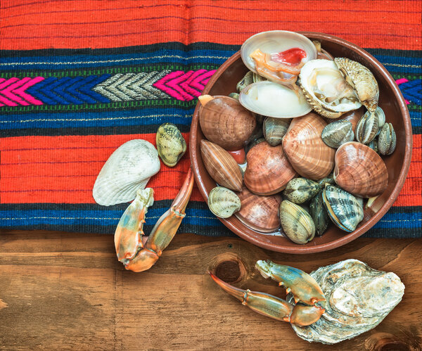 Морепродукты с крабовыми когтями и раковинами расположены на ткани этнических
.