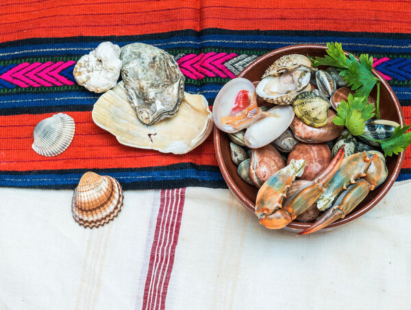 Морепродукты с крабовыми когтями и раковинами расположены на ткани этнических
.