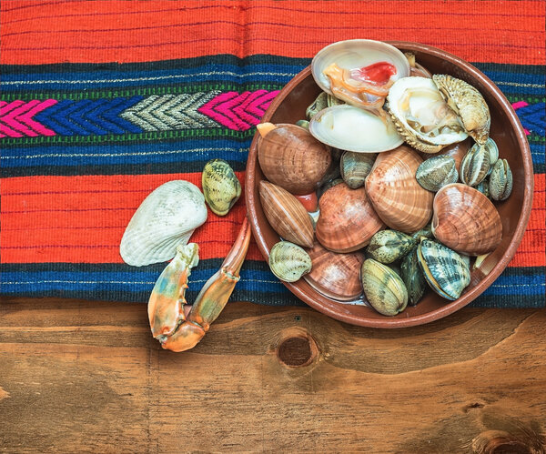 Морепродукты с крабовыми когтями и раковинами расположены на ткани этнических
.