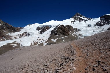 Karlı dağların büyüleyici güzelliği. Dağların tepesindeki kar ve kayaların manzarası
