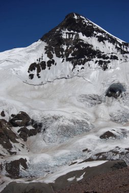 Karlı dağların büyüleyici güzelliği. Dağların tepesindeki kar ve kayaların manzarası