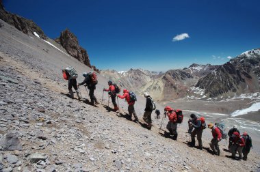 Karlı ve sarp dağlarda sıra sıra dağcıların aşırı koşullardaki hareketleri.