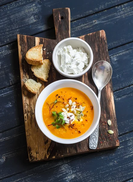 Healthy quinoa carrot soup with feta cheese, seeds and nuts on rustic dark wooden board. Delicious vegetarian food — Stock Image Healthy quinoa carrot soup with feta cheese, seeds and nuts on rustic dark wooden board. Delicious vegetarian food Stock Picture