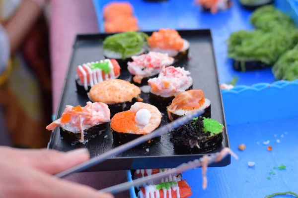 Plenty of sushi in a container for sell