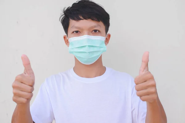 man wearing a mask thumbs up, detained at home, COVID-19.