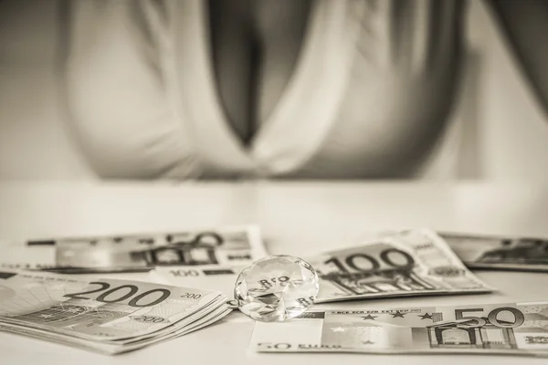 elmas ve masanın üzerinde banknot ile büyük göğüslü kız