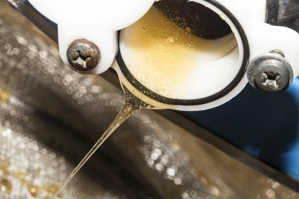 Miele grezzo scende da un contenitore in acciaio per la lavorazione — Foto Stock