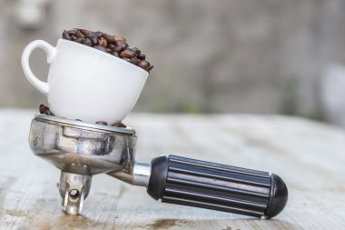 Makineli kahve çekirdekleri dolu bardak ve kol kahve