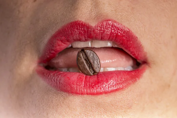 coffee bean between red lips
