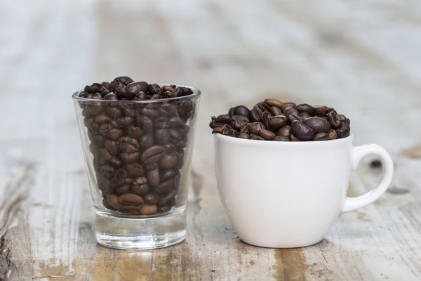 Чашка и стакан с кофейными бобами — стоковое фото