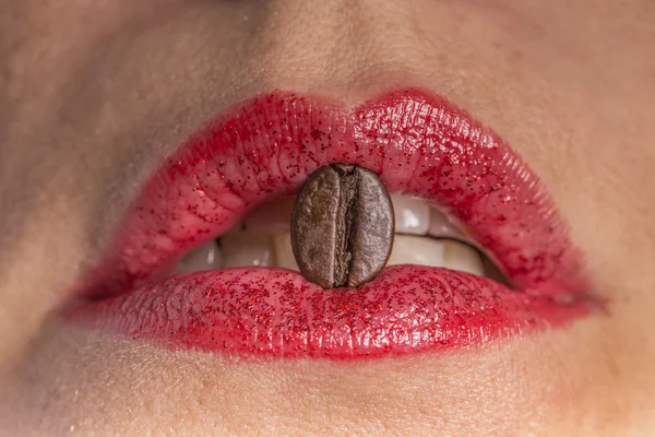 Coffee bean between red lips Stock Photo