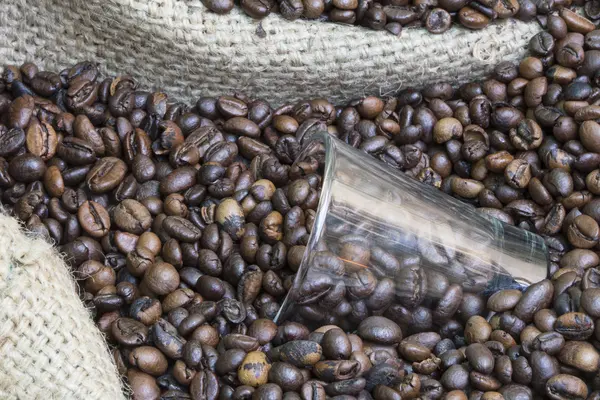 Vidrio en un saco de arpillera lleno de granos de café —  Fotos de Stock