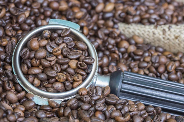 Рука кофеварки в мешочке полный кофейных зерен — стоковое фото
