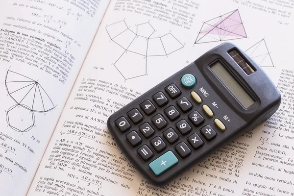 Calculator on opened book Stock Picture