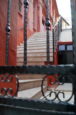 üst katta parmaklıkların arasından görünür