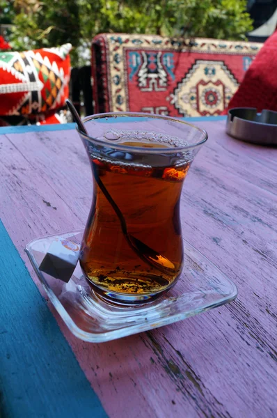 Red Turkish tea with sugar against a background of bright pillow — Stock Photo, Image